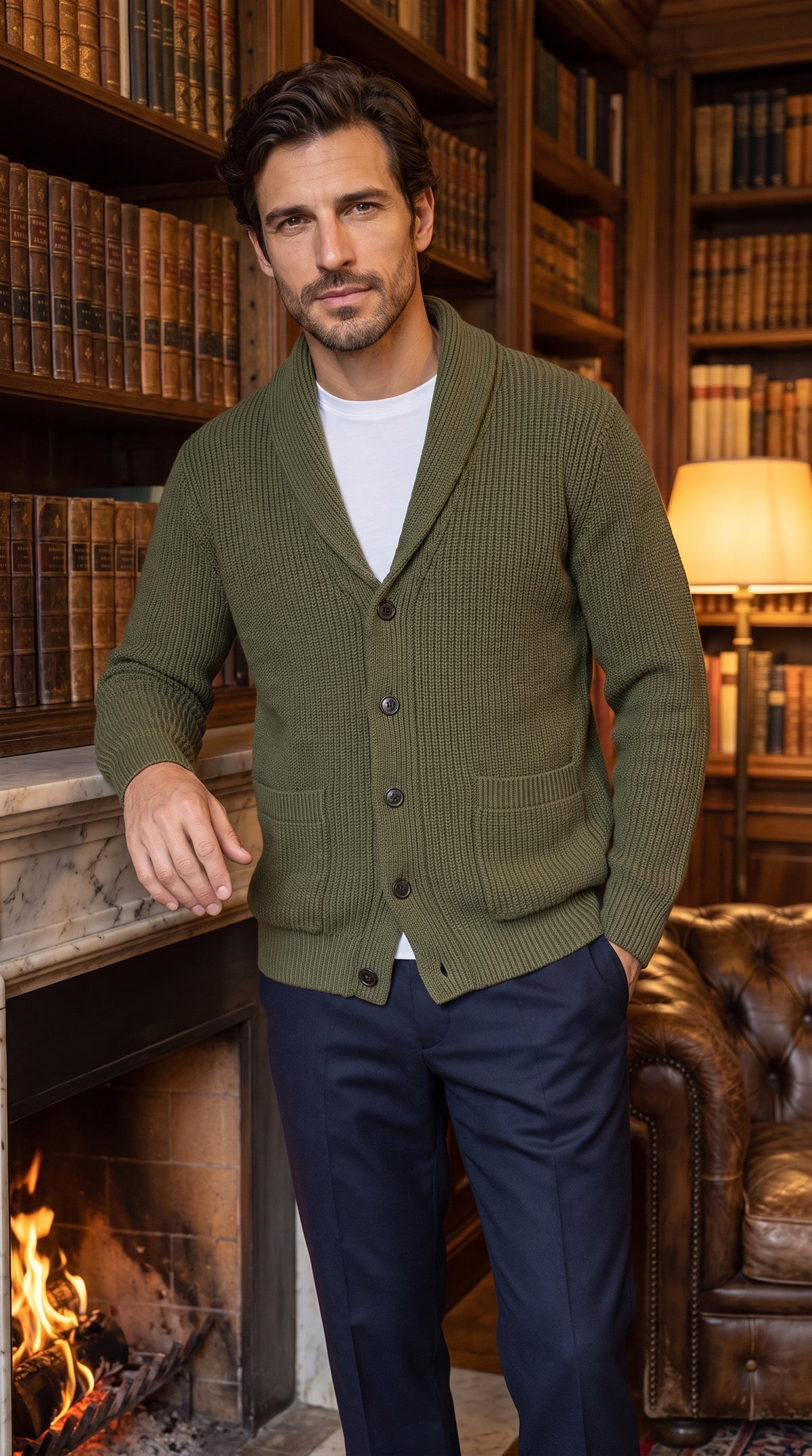 Cardigan verde oliva da uomo con collo a scialle, abbottonato, davanti al camino di una biblioteca